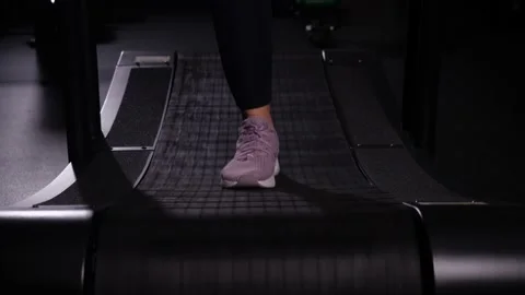 Close-up legs on a treadmill. Front view of sneakers exercising on a treadmill Stock Footage 149642247