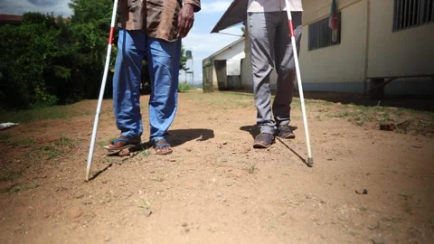 Close-up of the legs of two blind people walking using cane Stock Footage 258790117