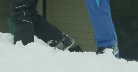 Close up of a legs walking through snow from condo in ski boots with snow pants Stock Footage 203994936