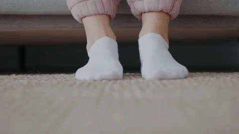 Close-up legs in white socks approaching the sofa and moving funny. Stock Footage 149935825