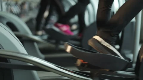 Close-up of legs of women using elliptical trainer to lose weight in the gym. Stock Footage 89785152
