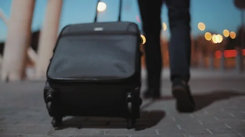 Close up legs young man pulling suitcase in modern airport terminal wearing Stock Footage 97273508