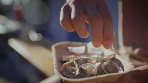 Close up of lemon being squeezed onto oysters Stock Footage 220309860