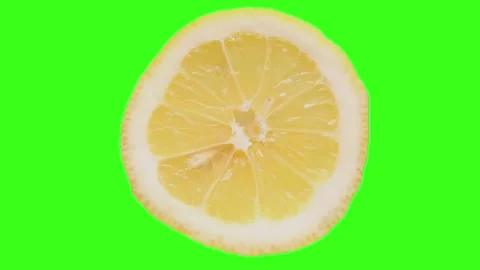 A close-up of a lemon cyclically rotates on a highlighted green background Stock Footage 193488622