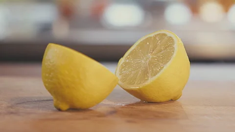Close up of lemon fruit cut in half lying on a wooden table. Slow motion studio Stock Footage 272925539