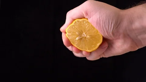 Close-up of a lemon. hand squeezes of lemon juice Stock Footage 122613077