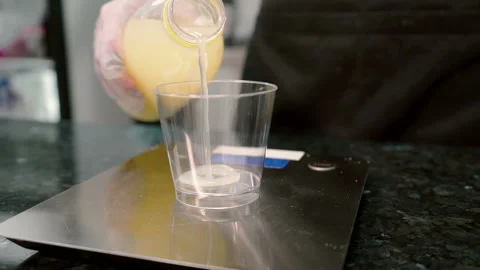 Close up of lemon juice is being poured from the bottle to the glass on the Stock Footage 87321741
