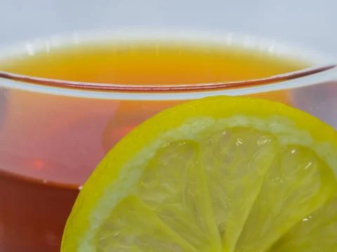 Close-up of lemon slice and cup of black tea. Stock Photos