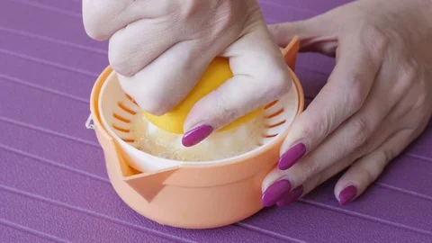 Close up lemonade extractor used by pedicured female slow mo Stock Footage 72878576
