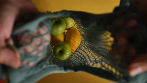 Close-up of lemons on a string bag on a yellow background Stock Footage 160384000