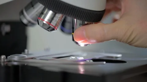 Close-up of lenses of laboratory microscope, coronavirus sample being examined Stock Footage 128642361