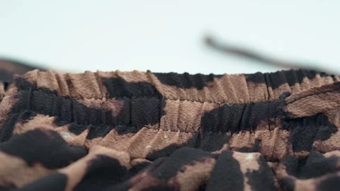 Close up of leopard print fabric texture with soft folds and pattern Stock Footage 331695320