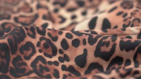 Close up of leopard print fabric texture with soft folds and pattern Stock Footage 331696726