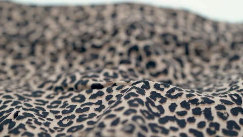 Close up of leopard print fabric texture with soft folds and pattern Stock Footage 331696794