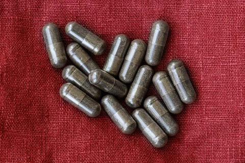 Close-up of licorice (DGL) capsules, on a red burlap rag. dietary concept. Foto stock