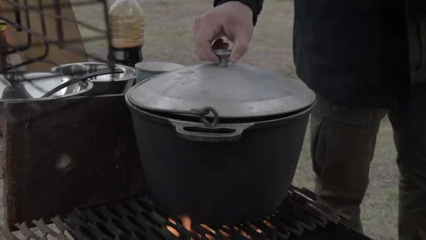 Close the lid of the boiler standing on the grate of the fire. cooking food Stock Footage 170425813