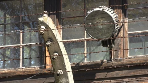 Close up of light and barbed wire on entry gate to Auschwitz concentration camp Video stock 85871894