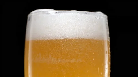 Close up Light beer is pouring into glass on black background Video stock 155355732