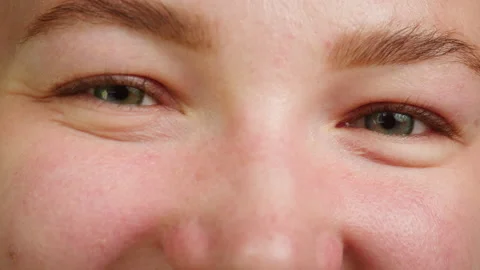 Close-up of a light-blue eye winking, opening and closing eyes. Advertising of Stock Footage 221939933