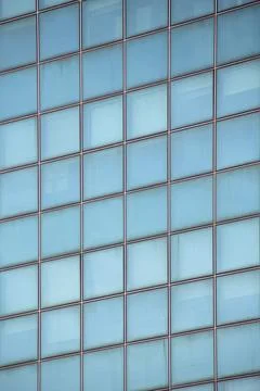 Close-up of a light blue glazed facade with square-shaped glass panels Stock Photos