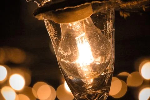 A close-up of a light bulb on black background and bokeh Stock Photos