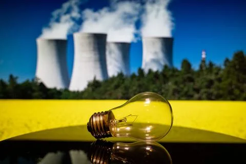 Close up of light bulb with nuclear power plant background Stock Photos
