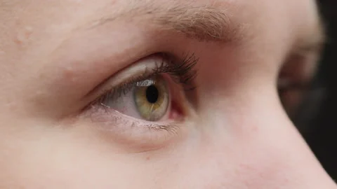 Close-up of a light eye blinking with painted lashes, opening and closing eyes Stock Footage 156752475