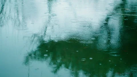 Close-up of light rain - ripples on the surface of the water with raindrops 動画素材 257056888