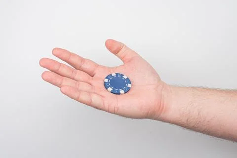 Close-up of a light-skinned hand holding a horizontal blue playing card Car.. Stock Photos