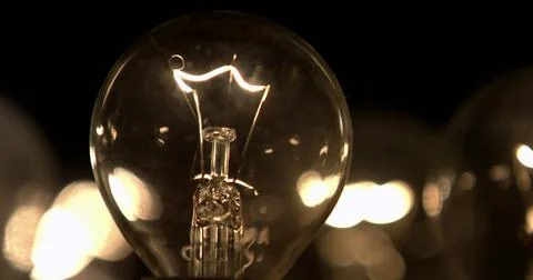 Close-up of a lightbulb on a black background. Stock Photos