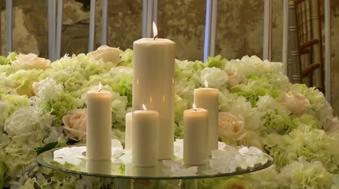 Close-up of lighted candles on flowers background Video stock 44920023