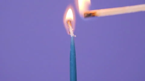 Close up on Lightning a candle on a birthday cake. Close up on burning blue cake Stock Footage 166907324