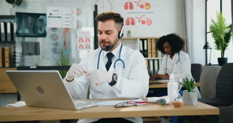 Close up of likable confident smart qualified bearded doctor in headset sitting Stock Footage 159821665