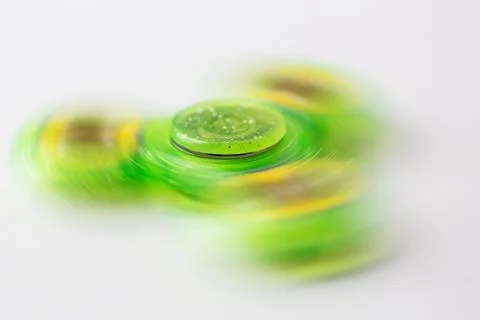 Close up of lime green spinning fidget spinner Stock Photos