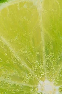 Close-up of a lime slice in liquid with bubbles. Slice of ripe lime in wate.. Stock-Fotos
