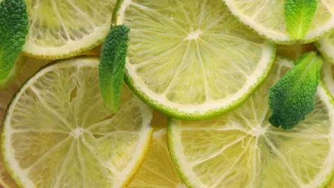 Close up of lime slices and mint leaves, rotation in circle Stock Footage 236424575