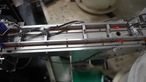 Close up of a linear feeder track carrying molded plastic parts on an automated Stockbeeldmateriaal 340901648