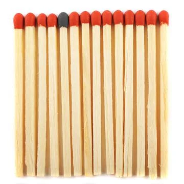 Close up of lined matches, one with a different color Stock Photos