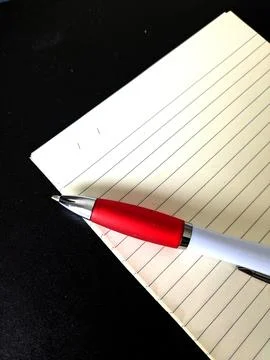 Close up of lined note paper and biro pen on a black background brainstormi.. Stock Photos