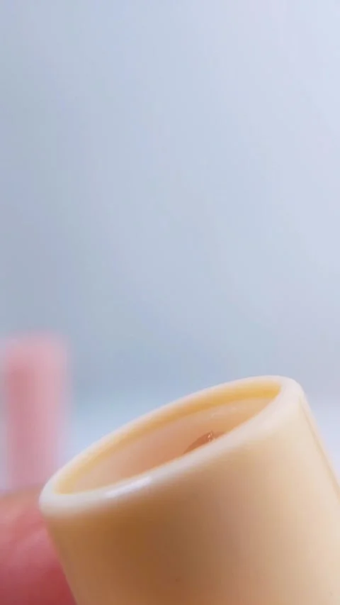 Close up of lip balm with yellow packaging slowly coming out. Isolated on s.. Stock Footage 340197627