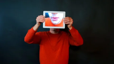 Close-up of a lips kiss on the tablet screen in the hands of a man. Stock Footage 122281572