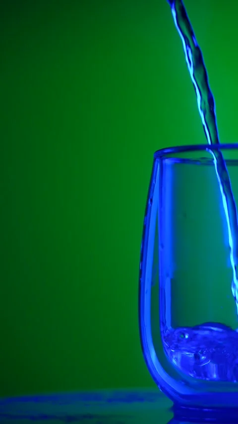 Close up of Liquid Being Poured into Glass with Colorful Lighting Vídeo Stock 332542785