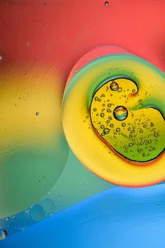 Close-up of liquid bubbles during mixing against the background of the rainbo Stock Photos