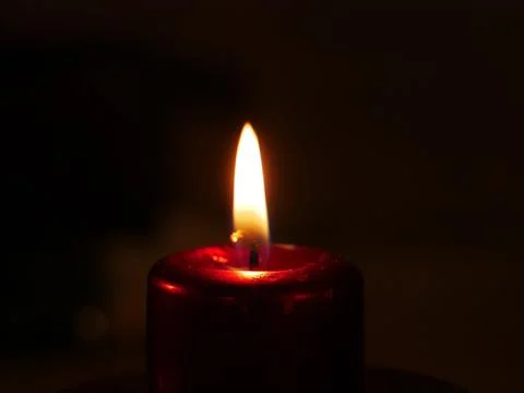Close-up on a lit candle to make a prayer Stock Photos