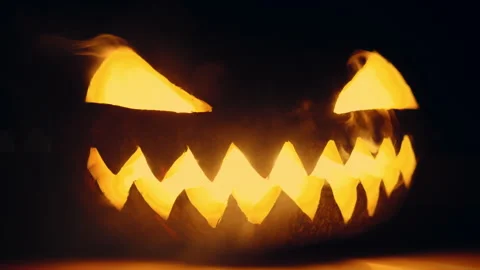 Close Up of a Lit Jack-O-Lantern on Halloween Night Stock Footage 277245898