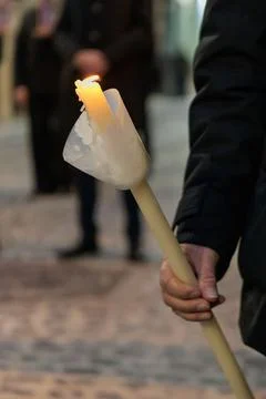 Close up of a lit processional candle with wax guard in the dark Stockfoto's