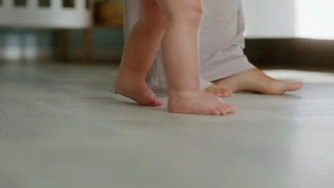 Close-up, little baby taking first steps. Child learning about the world Stock Footage 303040427