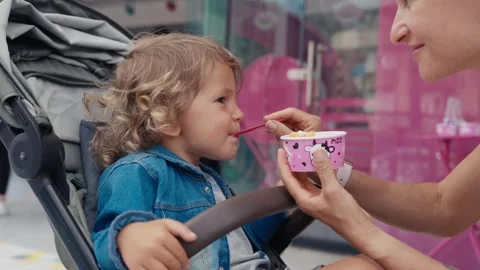 Close-up of a little boy and a young woman eating an ice cream together Stock Footage 244346237