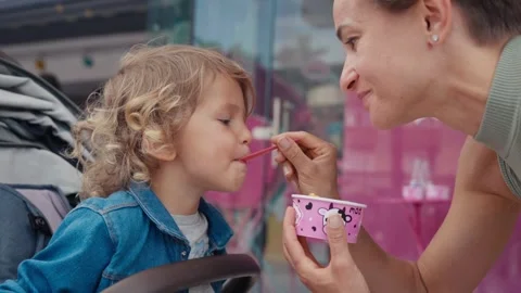 Close-up of a little boy and a young woman eating an ice cream together Stock Footage 244346267