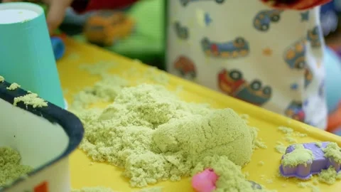 Close-up of a little boy playing with plastic toys and kinetic sand Stock Footage 150679638